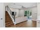 Living room featuring wood floors, a large sofa, and a staircase with black metal railings at 909 E Central Blvd, Orlando, FL 32801