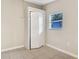 A bedroom with neutral walls, and tile floors, featuring a built-in closet and a window at 913 Ferndell Rd, Orlando, FL 32808