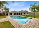 Backyard pool with brick deck, landscaping, palm trees, and backyard view at 922 Puma Trl, Winter Springs, FL 32708