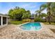 Backyard pool with brick deck, landscaping, palm trees, and privacy fence at 922 Puma Trl, Winter Springs, FL 32708