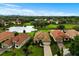 Aerial shot of homes with lush landscaping, pristine lawns, and a tranquil lake at 9235 San Jose Blvd, Howey In The Hills, FL 34737