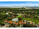 Aerial view of a home in a community surrounded by lakes and greenery at 9235 San Jose Blvd, Howey In The Hills, FL 34737