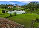 Beautiful backyard with a tranquil pond reflecting nearby homes and lush trees at 9235 San Jose Blvd, Howey In The Hills, FL 34737