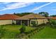 Backyard featuring a screened-in lanai, lush lawn, and well-maintained landscaping at 9235 San Jose Blvd, Howey In The Hills, FL 34737