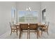 A dining room features a wooden table with seating for six and windows dressed with bright, white shutters at 9235 San Jose Blvd, Howey In The Hills, FL 34737