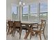 Bright dining room featuring a light fixture and a dining table with seating for six under large shuttered windows at 9235 San Jose Blvd, Howey In The Hills, FL 34737