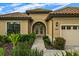 Charming home with a tile roof, beautiful landscaping, and a brick-paved walkway leading to an arched doorway at 9235 San Jose Blvd, Howey In The Hills, FL 34737