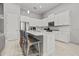 Kitchen island with seating, white cabinets, stainless appliances and marble countertops at 9235 San Jose Blvd, Howey In The Hills, FL 34737