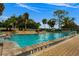 Large community pool surrounded by lush landscaping, lounge chairs, and clear blue water at 9235 San Jose Blvd, Howey In The Hills, FL 34737