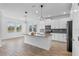 Modern kitchen boasts white cabinetry, a gray subway tile backsplash, and a large center island with pendant lighting at 9834 Introduction Way, Orlando, FL 32832