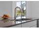 Close-up of kitchen sink and faucet with stainless steel sink and light gray countertops at 9834 Introduction Way, Orlando, FL 32832