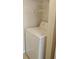 Washer machine within the condo, featuring storage shelves above it at 1029 S Hiawassee Rd # 2414, Orlando, FL 32835