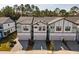 Aerial view of townhomes with paver driveways, garages, modern design and tree-lined street at 10364 Ebb Tide Ln, Orlando, FL 32821
