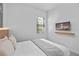 Comfortable bedroom features a TV for entertainment and a tranquil window view at 10364 Ebb Tide Ln, Orlando, FL 32821