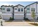 View of three-story townhomes, showing attached garages, manicured landscaping, and modern architectural design at 10364 Ebb Tide Ln, Orlando, FL 32821