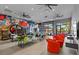 Large game room with vibrant art, modern tables, chairs, and an open garage door at 10364 Ebb Tide Ln, Orlando, FL 32821