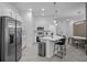 Modern, open concept kitchen with stainless steel appliances, quartz countertops, bar seating, and modern light fixtures at 10364 Ebb Tide Ln, Orlando, FL 32821