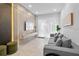 Bright living room featuring a gray sofa, a mounted TV, modern decor, and large windows at 10364 Ebb Tide Ln, Orlando, FL 32821
