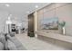 Open concept living area with a modern gray sofa, mounted TV, sleek decor, leading into a stylish kitchen at 10364 Ebb Tide Ln, Orlando, FL 32821