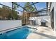 A screened in pool area with a pool, an outdoor grill and outdoor seating at 10364 Ebb Tide Ln, Orlando, FL 32821