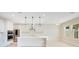 Bright, white kitchen boasts a spacious island, stainless steel appliances, and modern pendant lighting at 11464 Beau Repost Dr, Orlando, FL 32832