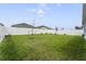 Spacious backyard with a lush green lawn, young trees, and a white fence at 1192 Sable Glen Dr, St Cloud, FL 34771