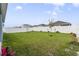 Well-maintained backyard with a lush green lawn, young trees, and a white fence at 1192 Sable Glen Dr, St Cloud, FL 34771