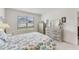 Comfortable bedroom with white furniture, a patterned quilt, and a window providing natural light at 1192 Sable Glen Dr, St Cloud, FL 34771