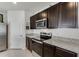 Modern kitchen with dark cabinets, stainless steel appliances, and granite countertops with convenient electrical outlets at 1192 Sable Glen Dr, St Cloud, FL 34771
