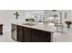 Kitchen island featuring dark cabinetry, granite countertops, stainless steel dishwasher, sink, and dining area beyond at 1192 Sable Glen Dr, St Cloud, FL 34771