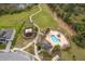 Aerial view of a community pool, playground, and walking trails in a lush green space at 12191 Sumter Dr, Orlando, FL 32824