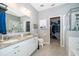 Bathroom featuring double sinks, granite countertops, and a large walk-in closet at 12191 Sumter Dr, Orlando, FL 32824