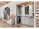 Chic bar area featuring wine storage, sink, gray cabinetry and easy access to the staircase at 1404 Kelso Blvd, Windermere, FL 34786