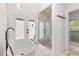 Bright bathroom featuring a soaking tub, glass shower with mosaic tile, and access to the outdoors at 1404 Kelso Blvd, Windermere, FL 34786
