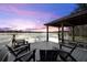 A covered dock with chairs overlooks a serene lake at sunset at 1404 Kelso Blvd, Windermere, FL 34786