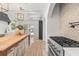 Modern kitchen features white cabinets, stainless appliances, brick archway, and gas range at 1404 Kelso Blvd, Windermere, FL 34786