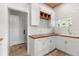 Bright mud room with white cabinets, butcher block counters, and decorative built-in wooden shelving at 1404 Kelso Blvd, Windermere, FL 34786