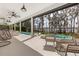 Relaxing outdoor patio with a hanging chair overlooking the pool and lake at 1404 Kelso Blvd, Windermere, FL 34786