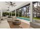A covered patio with an outdoor fireplace overlooks the water and pool at 1404 Kelso Blvd, Windermere, FL 34786