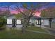 Charming single-story home with a manicured lawn, modern black trim, and a convenient carport for covered parking at 1607 31St Nw St, Winter Haven, FL 33881