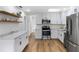 Renovated kitchen featuring floating shelves, stainless steel appliances, and open concept design at 1607 31St Nw St, Winter Haven, FL 33881
