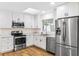 Well-lit kitchen features stainless steel appliances, light counter tops, and white cabinets at 1607 31St Nw St, Winter Haven, FL 33881
