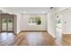 Bright living room with neutral walls, wood-look flooring, window, and open floorplan with access to other rooms at 1607 31St Nw St, Winter Haven, FL 33881