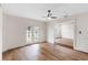 Bright living room featuring wood-look flooring, ceiling fan, and French doors leading to the yard at 1607 31St Nw St, Winter Haven, FL 33881