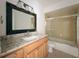 This bathroom features a black framed mirror, marble counters and a glass shower at 163 Springwood Cir # D, Longwood, FL 32750