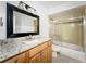 This bathroom features a black framed mirror, marble counters and a glass shower at 163 Springwood Cir # D, Longwood, FL 32750