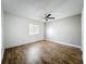This bedroom features hardwood floors, a ceiling fan, and a window for natural light at 163 Springwood Cir # D, Longwood, FL 32750