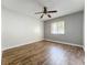 This bedroom features hardwood floors, a ceiling fan, and a window for natural light at 163 Springwood Cir # D, Longwood, FL 32750