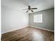 This bedroom features hardwood floors, a ceiling fan, and a window for natural light at 163 Springwood Cir # D, Longwood, FL 32750