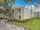 Building exterior view featuring lush greenery, landscaping, and clear blue skies at 163 Springwood Cir # D, Longwood, FL 32750